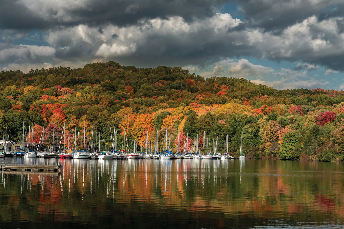 beautiful fall foliage on a mountain near boats dock