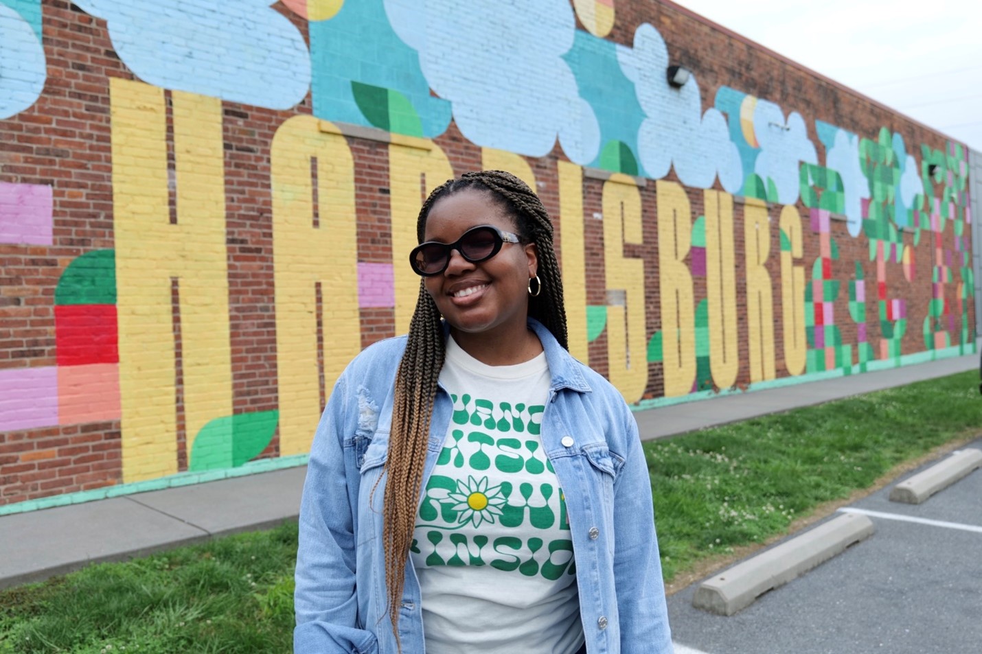 a girl posing for a photo with mural behind