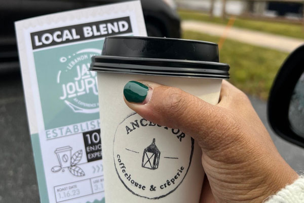 a person holding a cup of coffee in hand