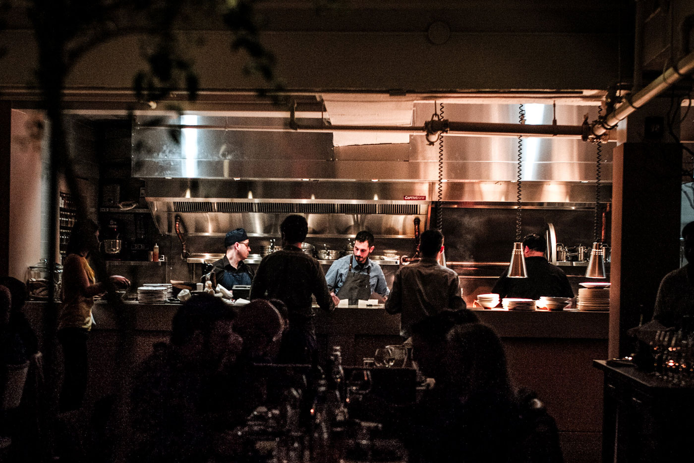 patrons enjoying food with kitchen view