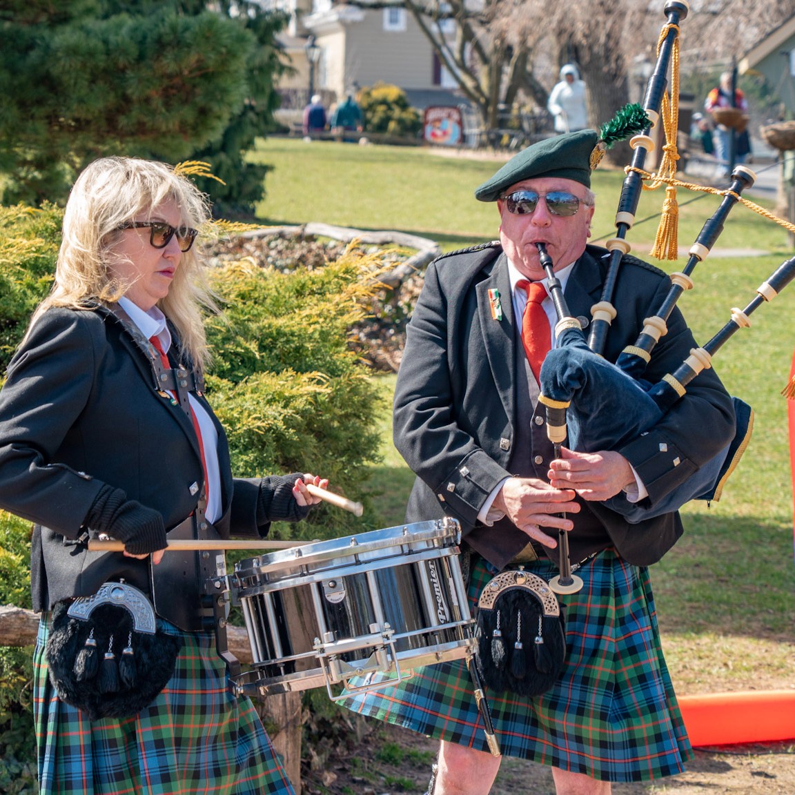 A couple playing bagpipe and drums dressed scottish