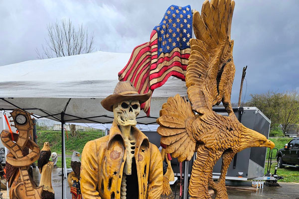 wood carved sculptures of a Bald eagle and cowboy skeleton