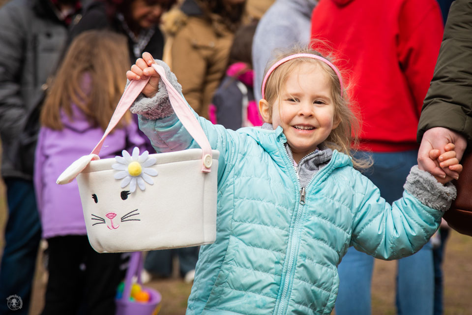 little girl holding egg collection basket