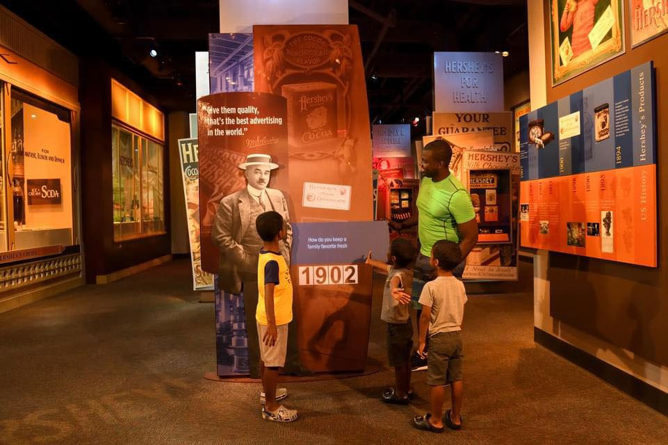 Three kids with an adult enjoying Hershey story the museum