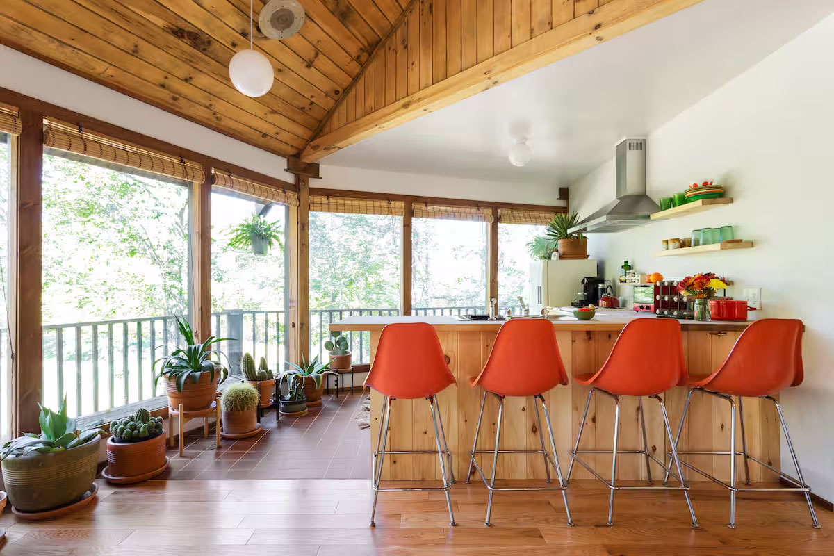 orange high chairs by kitchen island and indoor plants on side