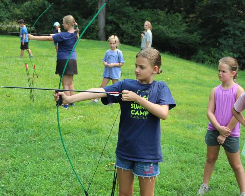 Kid shooting a bow and arrow